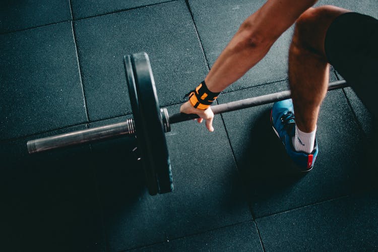 Person Wearing Black Shorts and Blue Lace-up Low-top Sneaker Holding Black Barbell